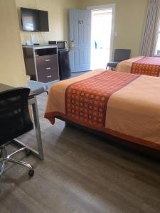Savannah的住宿－薩凡納汽車旅館，酒店客房 - 带两张床、一张桌子和一把椅子