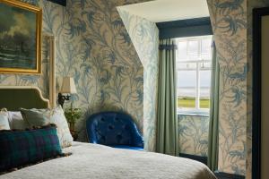 a bedroom with a blue chair next to a window at Marine Troon in Troon