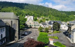 une vue aérienne sur une petite ville avec un parking dans l'établissement IDEAL MONTAGNE, à Le Mont-Dore