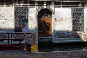 a building with a wooden door on the side of a canal at Gradenigo Apartments 767 in Venice