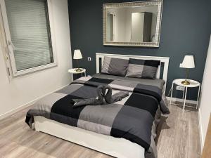 - une chambre avec un lit noir et blanc et un miroir dans l'établissement App 2 Mulhouse centre , 6 personnes, à Mulhouse