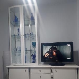 a tv in a white cabinet with glass shelves at Edificio Agata in Benalmádena