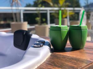 two green cups sitting on top of a table at Loft Casa Feliz in Rio das Ostras