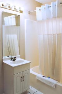 a white bathroom with a sink and a shower at Victorian Inn & Suites-York in York