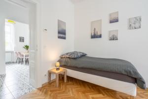a white bedroom with a bed and a table at revLIVING Apartments Eggenburg - Garten - Netflix - Disney Plus - Nespresso in Eggenburg