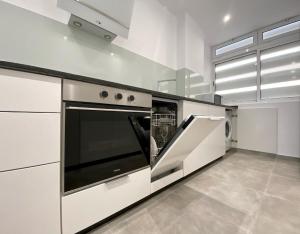 a kitchen with white cabinets and a dishwasher at Excelsior I Sea View Apartment in Maspalomas