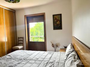 1 dormitorio con cama y ventana en Casa da Barriada II, en Bragança