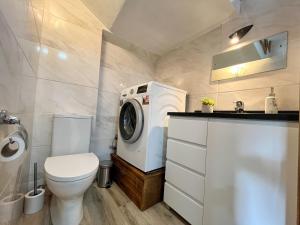 a bathroom with a toilet and a washing machine at Casa da Barriada II in Bragança