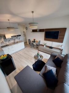 a living room with a couch and a kitchen at Apartament Kopernika-centrum Słupska in Słupsk