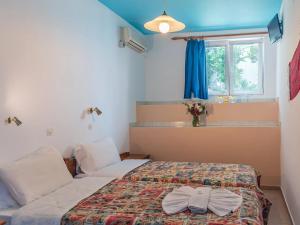 1 Schlafzimmer mit 2 Betten, einem Fenster und einem Bett in der Unterkunft Haris Studios in Palaiochóra