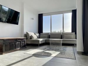 a living room with a couch and a tv at Excelsior I Sea View Apartment in Maspalomas
