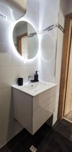 a white bathroom with a sink and a mirror at App12, Mulhouse centre 4 Personnes in Mulhouse +4 photos