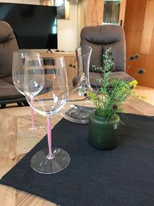 two wine glasses and a potted plant on a table at Klopeinerperle in Peratschitzen