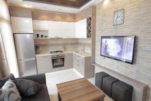 a living room with a couch and a tv and a kitchen at Apartment with Summer Terrace in Batumi