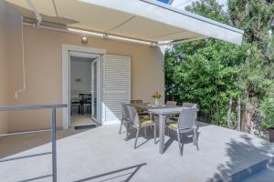 a patio with a table and chairs on a deck at Apartments with parking spaces Kraljevica - 18996 in Kraljevica