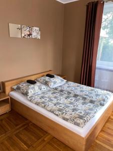 a bedroom with a bed with a comforter and a window at Zajazd Kadar in Wisła