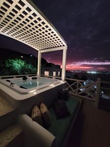 a jacuzzi tub on a balcony at night at Casa Mar da Grécia in Arraial do Cabo