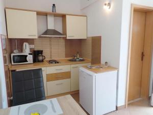 a kitchen with a white refrigerator and a microwave at Apartments with a parking space Seget Vranjica, Trogir - 19022 in Seget Donji