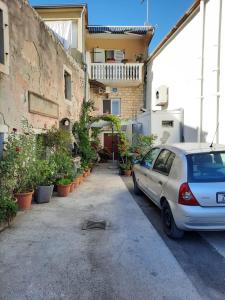 samochód zaparkowany przed budynkiem z roślinami w obiekcie Apartments by the sea Pakostane, Biograd - 19005 w Pakoštane