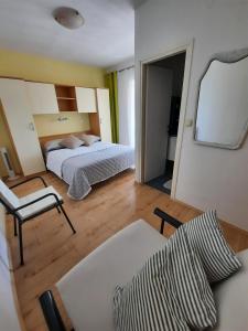 sypialnia z łóżkiem, krzesłem i lustrem w obiekcie Apartments by the sea Pakostane, Biograd - 19005 w Pakoštane