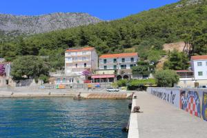 eine Gruppe von Gebäuden neben einem Wasserkörper in der Unterkunft Apartments by the sea Drvenik Donja vala, Makarska - 19006 in Drvenik