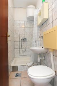 ein Bad mit einem WC, einem Waschbecken und einer Dusche in der Unterkunft Apartments by the sea Drvenik Donja vala, Makarska - 19006 in Drvenik