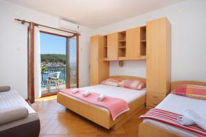 a bedroom with two beds and a balcony at Apartments by the sea Drvenik Donja vala, Makarska - 19006 in Drvenik