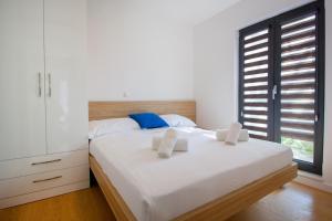 a bedroom with a bed with white sheets and a window at Apartments by the sea Makarska - 19145 in Makarska