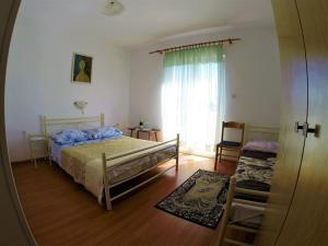 1 dormitorio con cama y ventana en Apartments and rooms with parking space Lopar, Rab - 19238 en Lopar