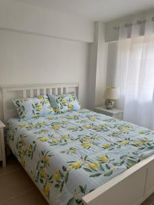 a bedroom with a bed with yellow flowers on it at Condominio Riviera Colonial in Calero