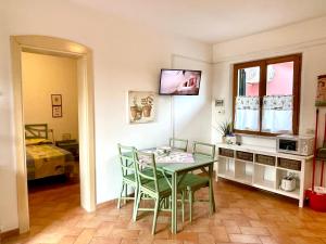 a dining room with a green table and chairs at Sera & Mattino Appartamenti by SolturElba in Capoliveri