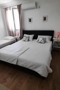 a bedroom with a large white bed with two pillows at Apartments by the sea Zuljana, Peljesac - 19080 in Žuljana