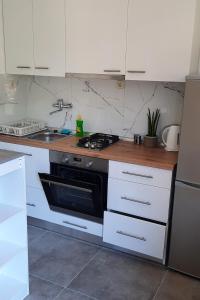 a kitchen with white cabinets and a black oven at Apartments by the sea Zuljana, Peljesac - 19080 in Žuljana