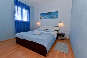 - une chambre avec un lit et une fenêtre avec des rideaux bleus dans l'établissement Holiday house with a parking space Razanac, Zadar - 19197, à Ražanac