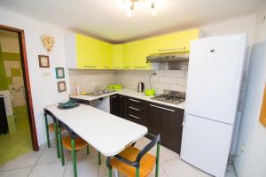 a kitchen with yellow cabinets and a white table and chairs at Apartments by the sea Veli Losinj, Losinj - 19196 in Veli Lošinj