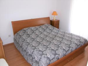 ein Schlafzimmer mit einem Bett mit einer grauen Bettdecke in der Unterkunft Apartments by the sea Baska, Krk - 19190 in Baška