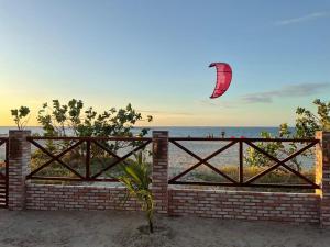 a kite flying over a brick fence on the beach at BEACH HOUSE - Suite 1 - NA PRAIA - BEACHFRONT in Barra Grande