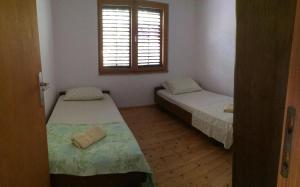 a small room with two beds and a window at Secluded fisherman's cottage Zman, Dugi otok - 19000 in Žman