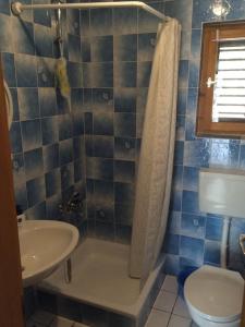 a bathroom with a sink and a shower and a toilet at Secluded fisherman's cottage Zman, Dugi otok - 19000 in Žman