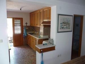 a kitchen with wooden cabinets and a counter top at Secluded fisherman's cottage Zman, Dugi otok - 19000 in Žman