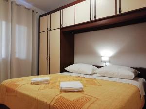 ein Schlafzimmer mit einem großen Bett mit zwei Handtüchern darauf in der Unterkunft Apartments by the sea Nin, Zadar - 19103 in Nin