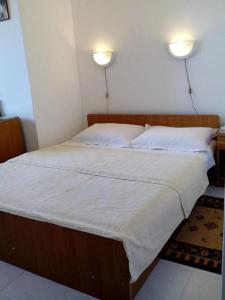 ein Bett in einem Schlafzimmer mit zwei Lichtern an der Wand in der Unterkunft Apartments by the sea Necujam, Solta - 19067 in Stomorska