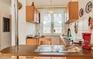 kuchnia z drewnianym stołem i oknem w obiekcie Holiday Home Mielno Akacjowa Ii w mieście Mielno