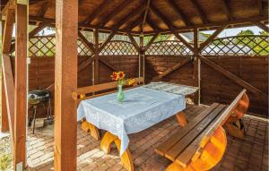 stół i ławka w drewnianej altanie w obiekcie Holiday Home Mielno Akacjowa Ii w mieście Mielno