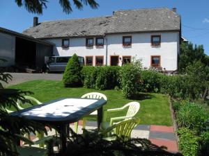 uma mesa e cadeiras em frente a uma casa em B&B Snow View Lodge em Medendorf