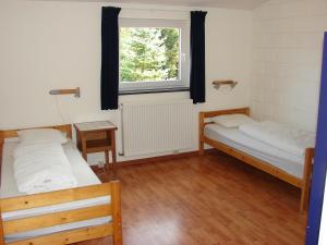 Duas camas num quarto com uma janela em B&B Snow View Lodge em Medendorf