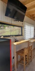 een keuken met een houten tafel en een fornuis bij Tinyhouse Boyeruca Lodge. Maravillosas vistas de Bosque, Mar y Cielo in Vichuquén