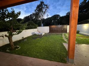 a backyard with a grass yard with a fence at Casaflavio in Torvaianica