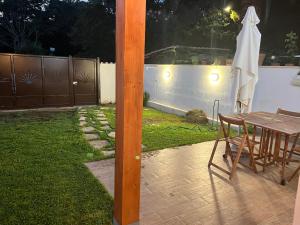 a table and chairs and an umbrella in a backyard at Casaflavio in Torvaianica