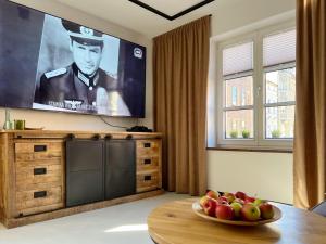 - un salon avec une télévision et une corbeille de fruits sur une table dans l'établissement Apartament Hansa Klossa, à Olsztyn